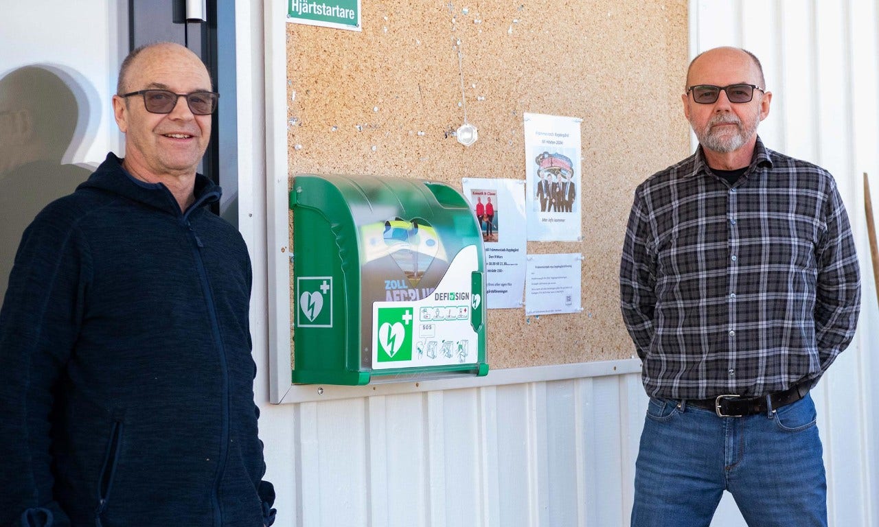 Två personer vid en hjärtstartare